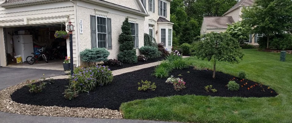 Landscape bed with mulch in front of a home in Old Orchard, PA.
