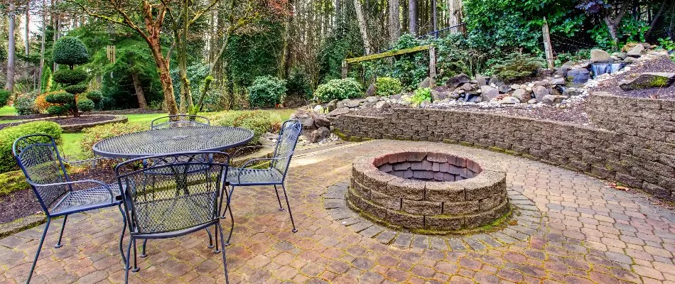 Round fire pit on a patio in Fullerton, PA, with a seating wall.