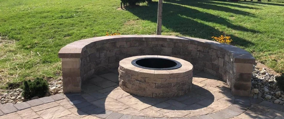 Seating wall in Hereford Township, PA, around a fire pit near a lawn.