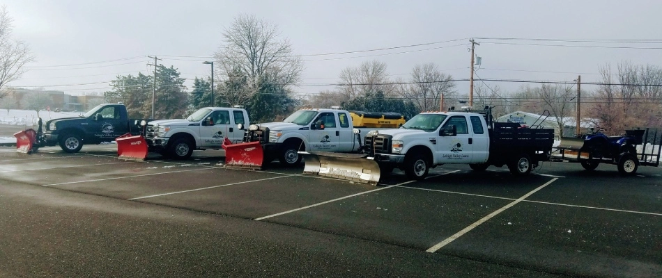 Snow plow trucks lined up in commercial parking lot in Wescosville, PA.