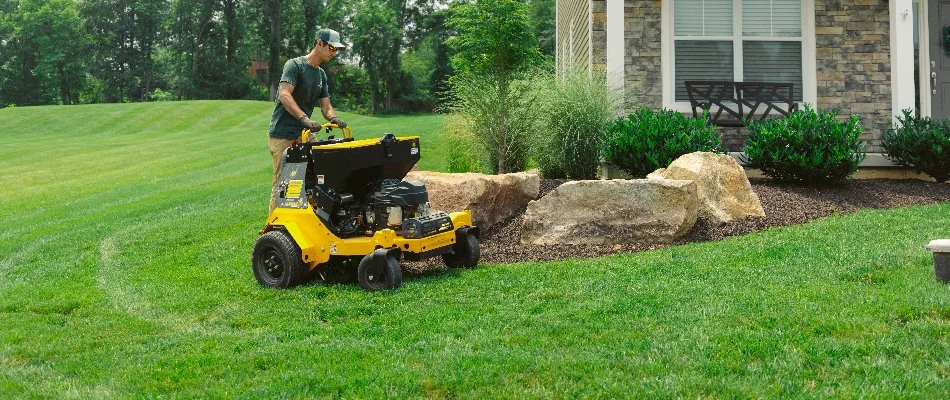 Worker performing lawn care service in Cetronia, PA.